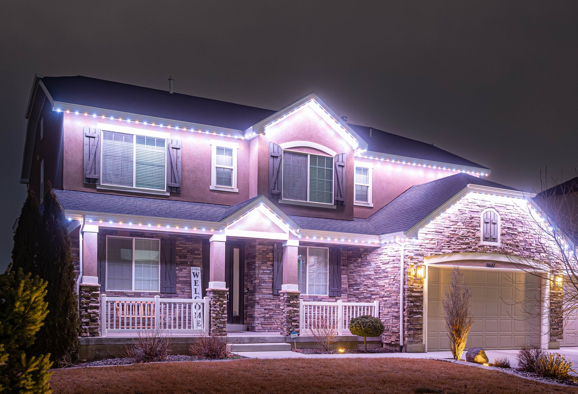 Home with warm-white permanent roofline lighting at night